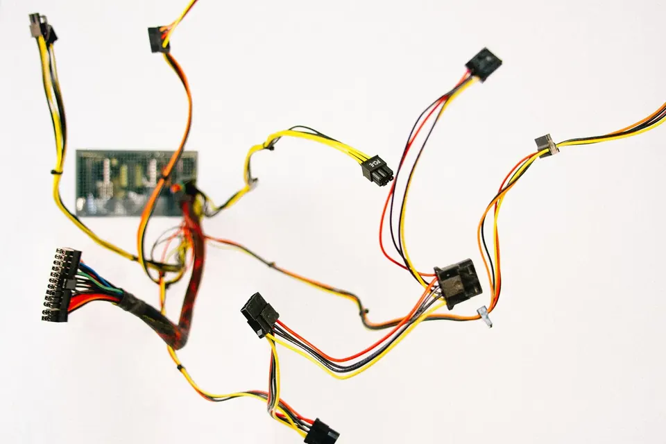 Câbles électriques de couleur et connecteurs d'ordinateur étalés sur un fond blanc