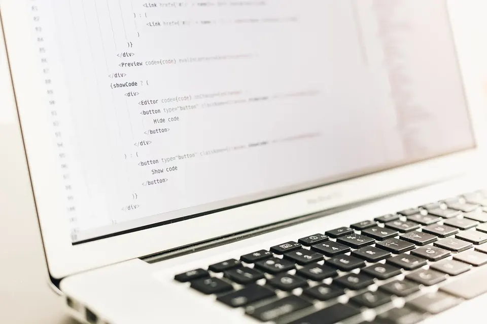 Écran d'ordinateur portable affichant des lignes de code sur fond clair